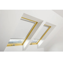 Zwei Dachfenster mit Jalousien in einem hellen Raum.