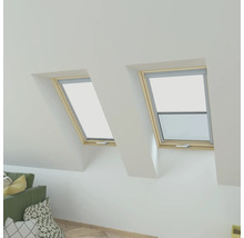 Zwei Dachfenster mit geöffnetem Fenster und Rollo in einem Dachzimmer