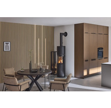 Wohnraum mit Kaminofen, Esstisch und Stühlen vor einer Holzpaneelwand