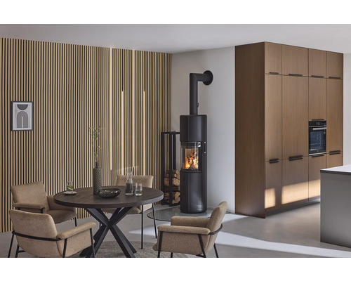 Wohnraum mit Kaminofen, Esstisch und Stühlen vor einer Holzpaneelwand