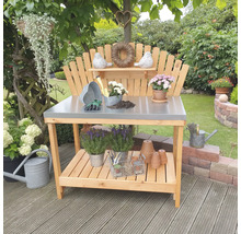 Gartenszene mit einem Pflanztisch aus Holz mit Metallplatte und Gartenzubehör