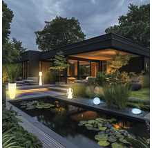 Modernes Haus mit Teich, Gartenbeleuchtung und Bepflanzung in der Dämmerung