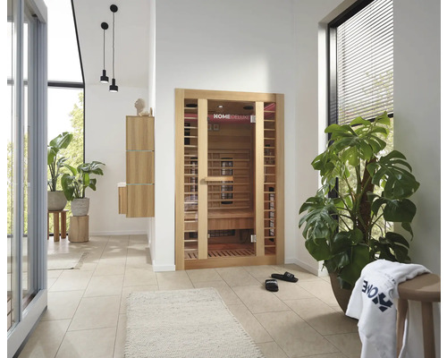 Innenaufnahme eines Badezimmers mit Infrarotsauna, Pflanzen und Bademöbeln in hellem und organisiertem Design.