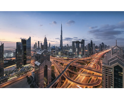 Skyline von Dubai mit Wolkenkratzern und beleuchteten Autobahnen bei Dämmerung