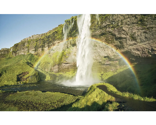 Wasserfall mit Regenbogen in einer grünen Landschaft