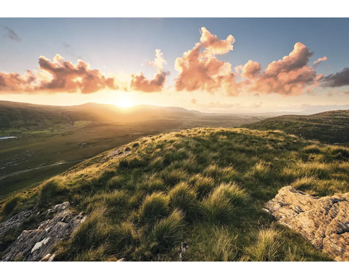 Landschaft mit Hügeln, Gras und Sonnenaufgang