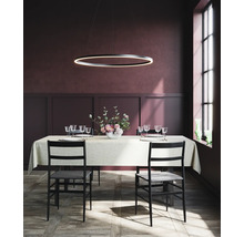 Esstisch mit Gedeck, Stühlen und ringförmiger Hängelampe in einem Esszimmer.