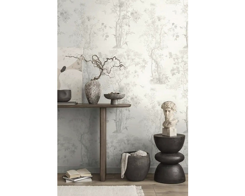 Dekoratives Zimmer mit floraler Tapete, Holztisch, Kunstwerken und Ziergegenständen.