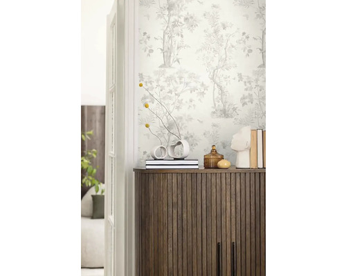 Dekoratives Zimmer mit gemusterter Tapete, Holzkommode und Vasen