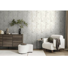 Wohnzimmer mit gemusterter Tapete, Kommode, Sessel und Fußhocker für eine helle und organisierte Atmosphäre.