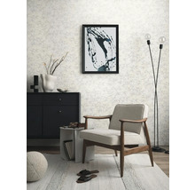 Wohnzimmer mit Sessel, Kommode, Stehlampe und gemusterter Tapete für eine helle und organisierte Atmosphäre