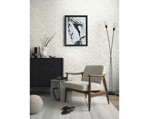 Wohnzimmer mit Sessel, Kommode, Stehlampe und gemusterter Tapete für eine helle und organisierte Atmosphäre