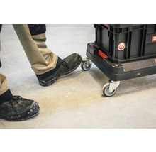 Werkzeugkoffer auf Rollen mit Person im Hintergrund