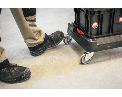 Werkzeugkoffer auf Rollen mit Person im Hintergrund