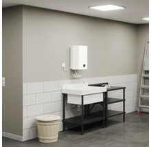Waschbecken mit Unterschrank, Boiler und Leiter in einem hellen Raum