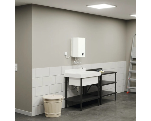 Waschbecken mit Unterschrank, Boiler und Leiter in einem hellen Raum