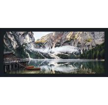 Fotografie eines Bergsees mit einem Holzhaus und Booten