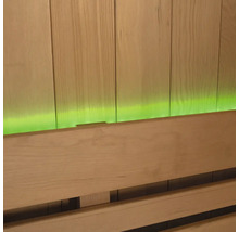 Nahaufnahme einer Saunabank vor einer Holzvertäfelung mit grüner Beleuchtung