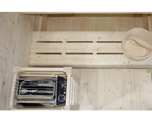 Innenausstattung einer Sauna mit Holzverkleidung, Bank, Saunaofen und Aufgusskübel mit Schöpfkelle