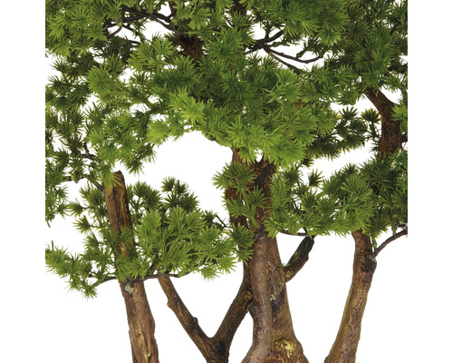 Nahaufnahme eines künstlichen Bonsai-Baums mit grünen Blättern und braunem Stamm.