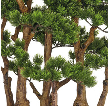 Nahaufnahme von künstlichen Kiefernzweigen mit braunen Stämmen und grünen Nadeln.