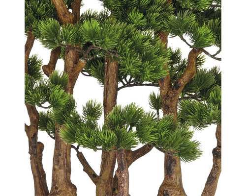 Nahaufnahme von künstlichen Kiefernzweigen mit braunen Stämmen und grünen Nadeln.