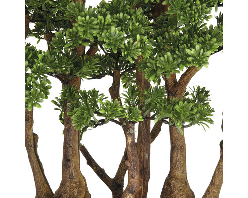 Detailaufnahme von Kunstbäumen mit grünen Blättern und braunen Stämmen.