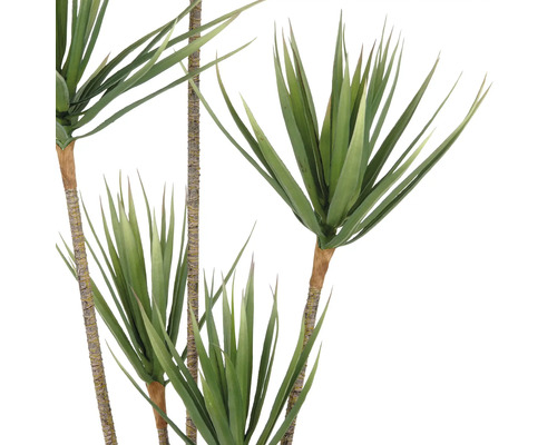 Künstliche Grünpflanze mit langen, spitzen Blättern an braunen Stängeln.