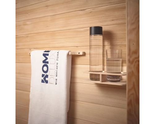 Handtuchhalter mit Handtuch und Getränkeablage an einer Holzwand