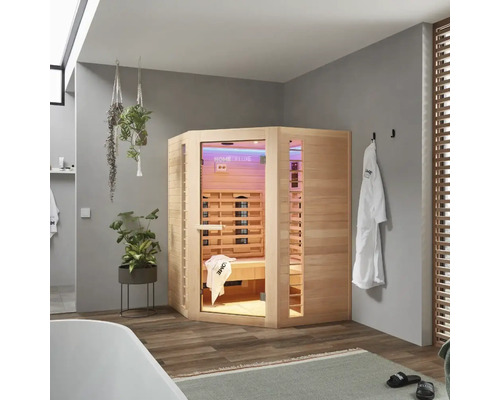 Eckige Infrarotsauna aus Holz in einem Badezimmer mit Badewanne, Handtüchern und Pflanzen.
