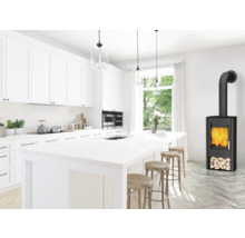 Heller Küchenraum mit Kochinsel, Hocker und Kaminofen.