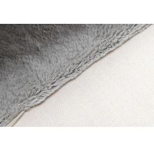 Detailaufnahme einer grauen Kuscheldecke mit weißer Unterseite.