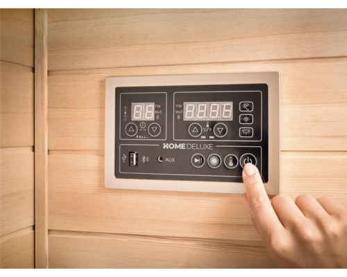 Nahaufnahme eines Bedienfelds in einer Sauna mit einer Hand, die den Ein- und Ausschaltknopf drückt