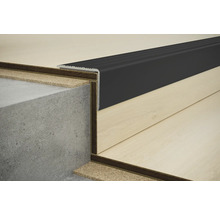 Nahaufnahme einer Treppenkante mit schwarzem Profil auf einer Betontreppe und Laminatboden.