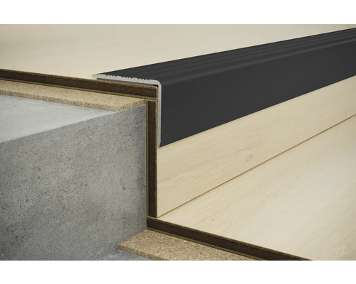 Nahaufnahme einer Treppenkante mit schwarzem Profil auf einer Betontreppe und Laminatboden.