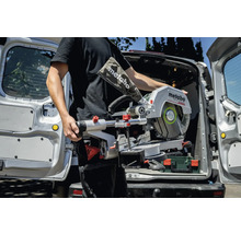 Mann trägt Metabo Kapp- und Gehrungssäge aus dem Kofferraum eines Lieferwagens