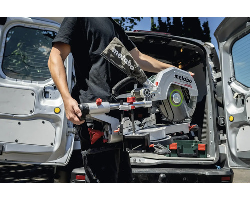 Mann trägt Metabo Kapp- und Gehrungssäge aus dem Kofferraum eines Lieferwagens