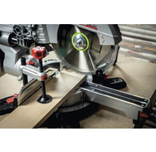 Kapp- und Gehrungssäge schneidet ein Holzbrett.