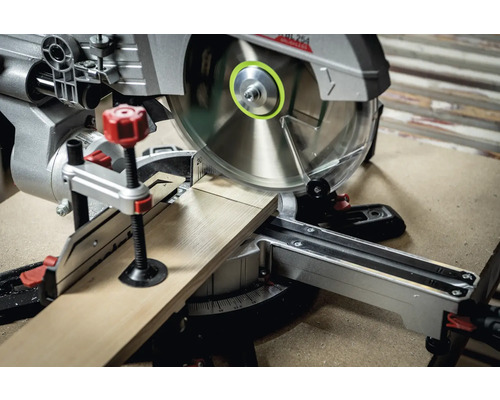 Kapp- und Gehrungssäge schneidet ein Holzbrett.