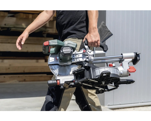Eine Person trägt eine Metabo Kapp- und Gehrungssäge.