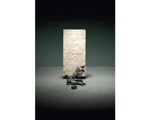 Metabo Kapp- und Gehrungssäge vor einer Wand aus Mauersteinen