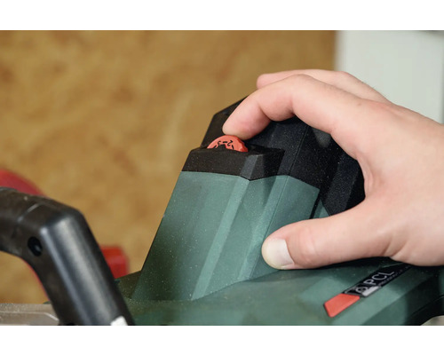 Hand stellt Tiefeneinstellung an einer Akku-Heckenschere ein.