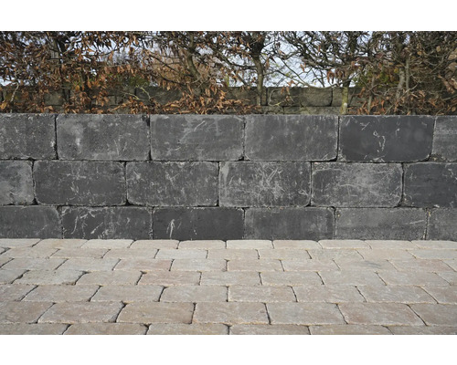 Mauer aus Betonsteinen mit Pflastersteinen im Garten