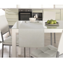 Esstisch mit Tischläufer, Geschirr und Stühlen in einer Küche.