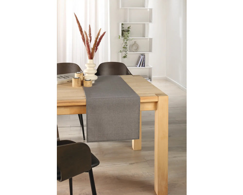 Gedeckter Holztisch mit grauem Tischläufer, Dekoration und Stühlen