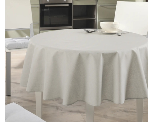 Runder Tisch mit Tischdecke und Geschirr in heller Küche