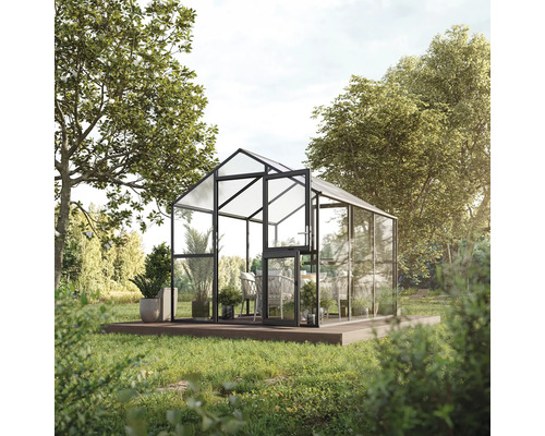 Gewächshaus mit geöffneter Tür und Pflanzen auf einer Holzplattform im Garten.