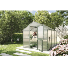 Gewächshaus im Garten mit geöffneter Tür und Gartenwerkzeug