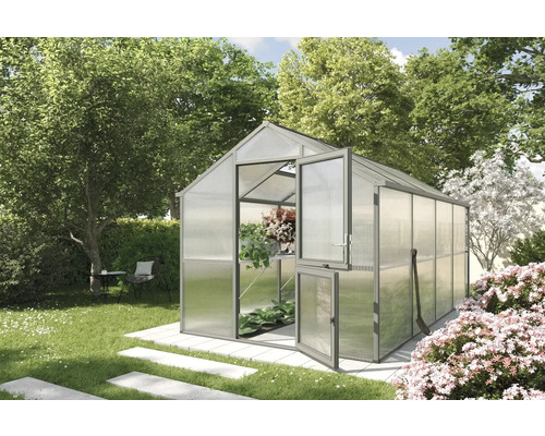 Gewächshaus mit geöffneter Tür in einem Garten mit Bäumen