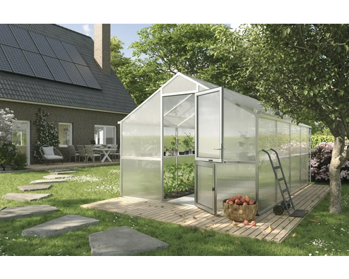 Gewächshaus im Garten mit geöffneter Tür, Karren und Korb mit Äpfeln